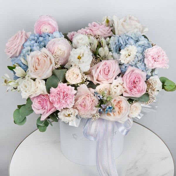 Blue/purple hydrangea - 2, Peony style roses - 3, Ranunculus Pink - 3, lisianthus - 3, Pink carnation - 5, Alstromeria white, soft pink - 7, Peony sprayrose - 2, Peony rose pink 'OHara' - 3, Round flower box medium, Oasis, Ozotamnus, Oksipetalum, Eucalyptus, Ribbon