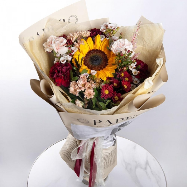 Sunflower - 1, Daisy poms Santini pink, purple - 5, Carnation red - 4, Carnation white, cream - 3, Waxflower (1 pc.), Astilbe, Pistachio, Wrapping Paper