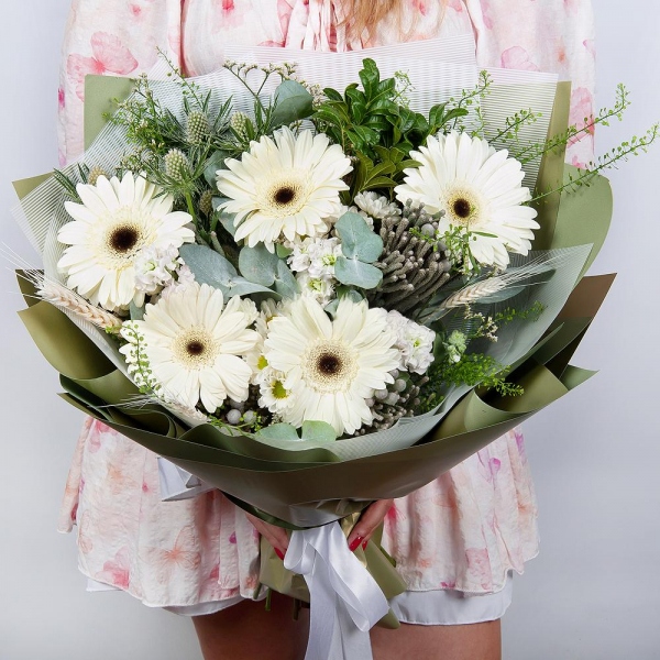 Gerbera white - 9, White Matthiola - 3, Pistachio, Eucalyptus, Brunia Green Lanuginosa (1 pc.), Eryngium, Green bell (1 pc.), Dried flowers in assortment, Wrapping Paper